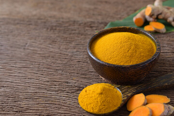 Turmeric powder and fresh turmeric (curcumin) on wooden background,Used for cooking,Herbal,copy...