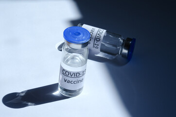 Creative ideas of vaccination concept. Top view of syringe and vaccine vial glass bottles for vaccination against COVID-19. Coronavirus pandemic. Copy space.