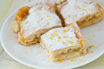 Lemon pie with filling, icing sugar and lemon zest