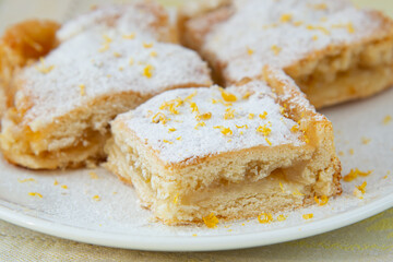 Lemon pie with filling, icing sugar and lemon zest
