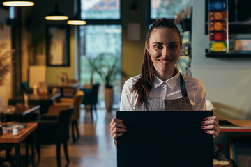 woman waitress holding blank sign board in restaurant