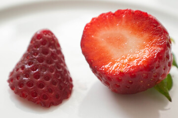 Strawberries cut on a white plate. Isolated