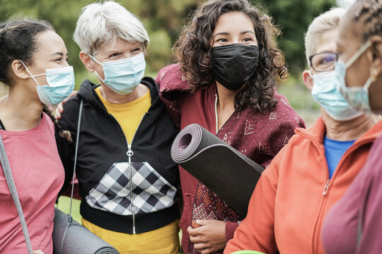 Multi generational women having fun before yoga class wearing safety masks during coronavirus outbreak at park outdoor - Main focus on center girl face - Powered by Adobe