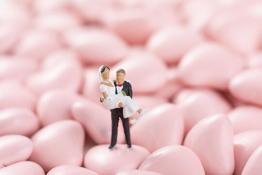 Valentine's Day With Wedding Figures On A Heart-shaped Pink Candies Background