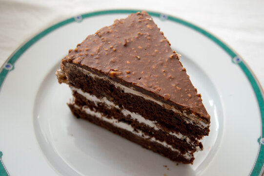 Chocolate sponge cake slice close-up. Side and top view of a chocolate cake on a plate.