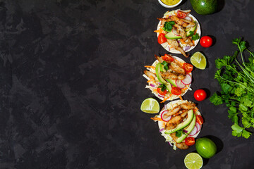 Tacos with crispy fish, avocado, guacamole sauce and lime on dark background. Top view with copy space. Mexican cuisine - 427885453