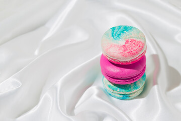 Creative background made with macaroons and white silk sheet. Minimal style composition.