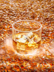 A glass of classic corn whiskey (bourbon) stands on corn seeds. Vertical photo.