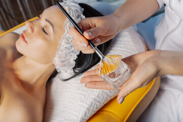 Professional beautician woman stirring mask in glassware.