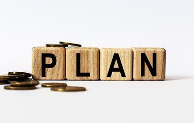 wooden cubes and PLAN, coins, the concept of taxation, increase taxes and fees