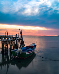 A fisherman boat at sunset on the Carrasqueira Palafitic pier in Comporta, Portugal.