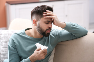 Man suffering from runny nose at home