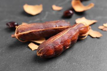 Peeled tamarind pods on black table, closeup