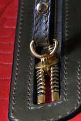 Close-up of a padlock on a genuine red leather bag. Macro close-up. High quality photo