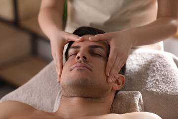Fototapeta na wymiar Man receiving facial massage in beauty salon