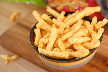 Bowl with tasty potato chips on wooden background .
