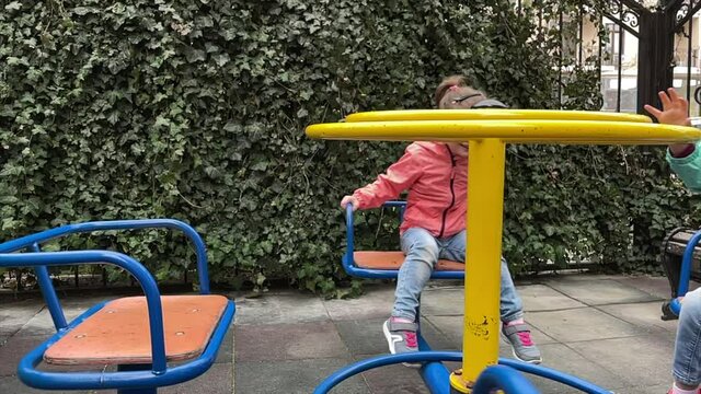 Little girls playing on swing at backyard