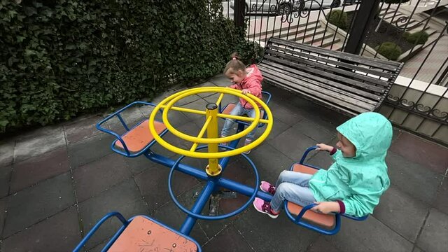 Little girls playing on swing at backyard
