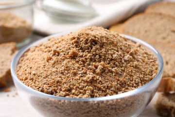 Fresh breadcrumbs in bowl on table, closeup