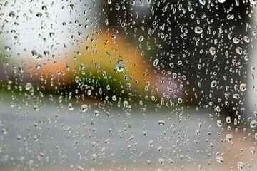 drops on glass, against the background of a blooming garden