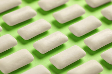 Many chewing gum pieces on green background, closeup