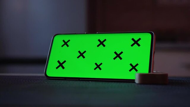 Smartphone with a green screen put horizontally with a phone stand, Free space for editing and text