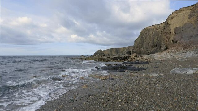 rocky beach with cliffs and cloudy landscape. Kilfarrasy Beach. Co.Waterford Coastline, Ireland