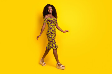 Full length body size view of attractive slender cheerful girl strolling good mood isolated over bright yellow color background