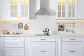 Fototapeta na wymiar Elegant kitchen interior with modern stove and stylish furniture