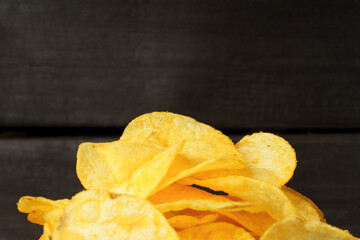 close-up of a bunch of potato chips on a dark wood