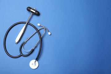 Reflex hammer, stethoscope and space for text on blue background, flat lay. Nervous system diagnostic