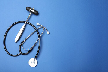 Reflex hammer, stethoscope and space for text on blue background, flat lay. Nervous system...