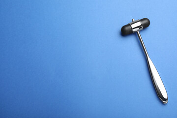 Reflex hammer on blue background, top view with space for text. Nervous system diagnostic