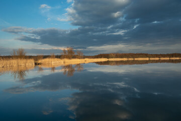 A mirror image of dark clouds in the water of a calm lake