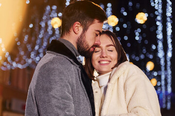 Closeness of the people. Happy young couple celebrating New year outdoors on the street