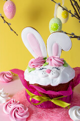 Easter cupcake decorated with bunny ears on a yellow background. Spring church holiday concept.