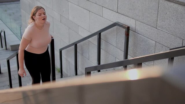 Exhausted woman feeling discomfort, climbing stairs, fat burning workout, health