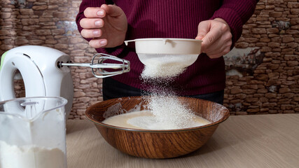 Sifting flour into a bowl. The cooking process. Selective focus.