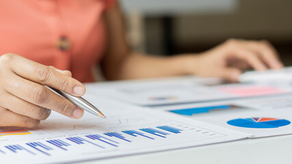Business people or finance professionals analyze graphs, business reports and financial charts at...