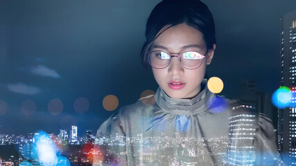 夜のオフィスで仕事をする女性