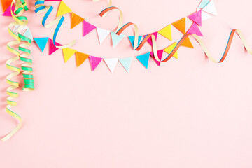 Party background with streamers and confetti on pastel pink background.