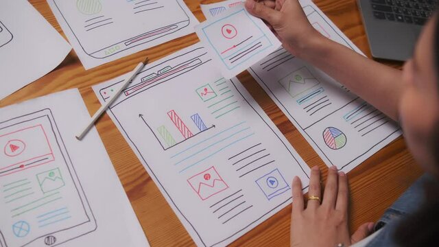 Web designer working laptop responsive design. Creative UI Ux designer teamwork meeting planning designing wireframe layout application development for smartphone screen mobile phone technology