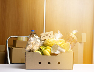 cardboard box with various products, fruits, pasta, sunflower oil in a plastic bottle and preservation.