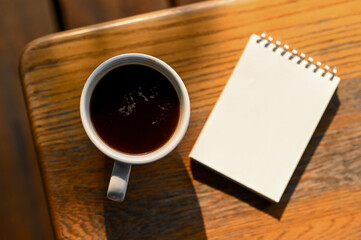 Coffee and a notebook on the table, Top view shot.
