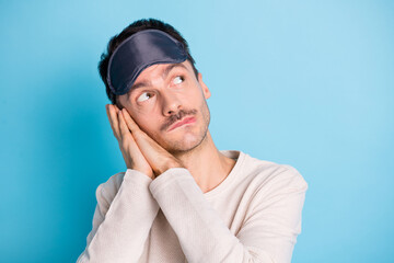 Portrait of nice worried minded brunet guy wearing sleep mask thinking copy space isolated over bright blue color background