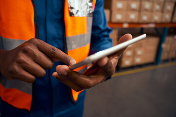 Midsection of a male worker pointing at digital tablet in factory