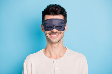 Portrait of nice attractive cheerful brunet guy wearing sleep mask good nap isolated over bright blue color background