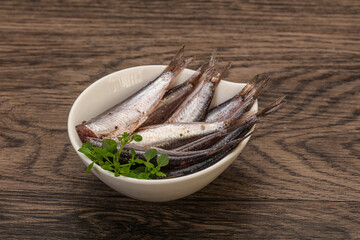 Anchovies in the bowl served basil leaves