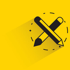 crossed pencils with shadow on yellow background