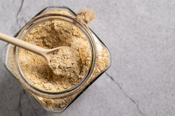 nutritional yeast in flakes, deactivated, not live, B vitamins, in a jar, focus on a spoon, close-up, top view